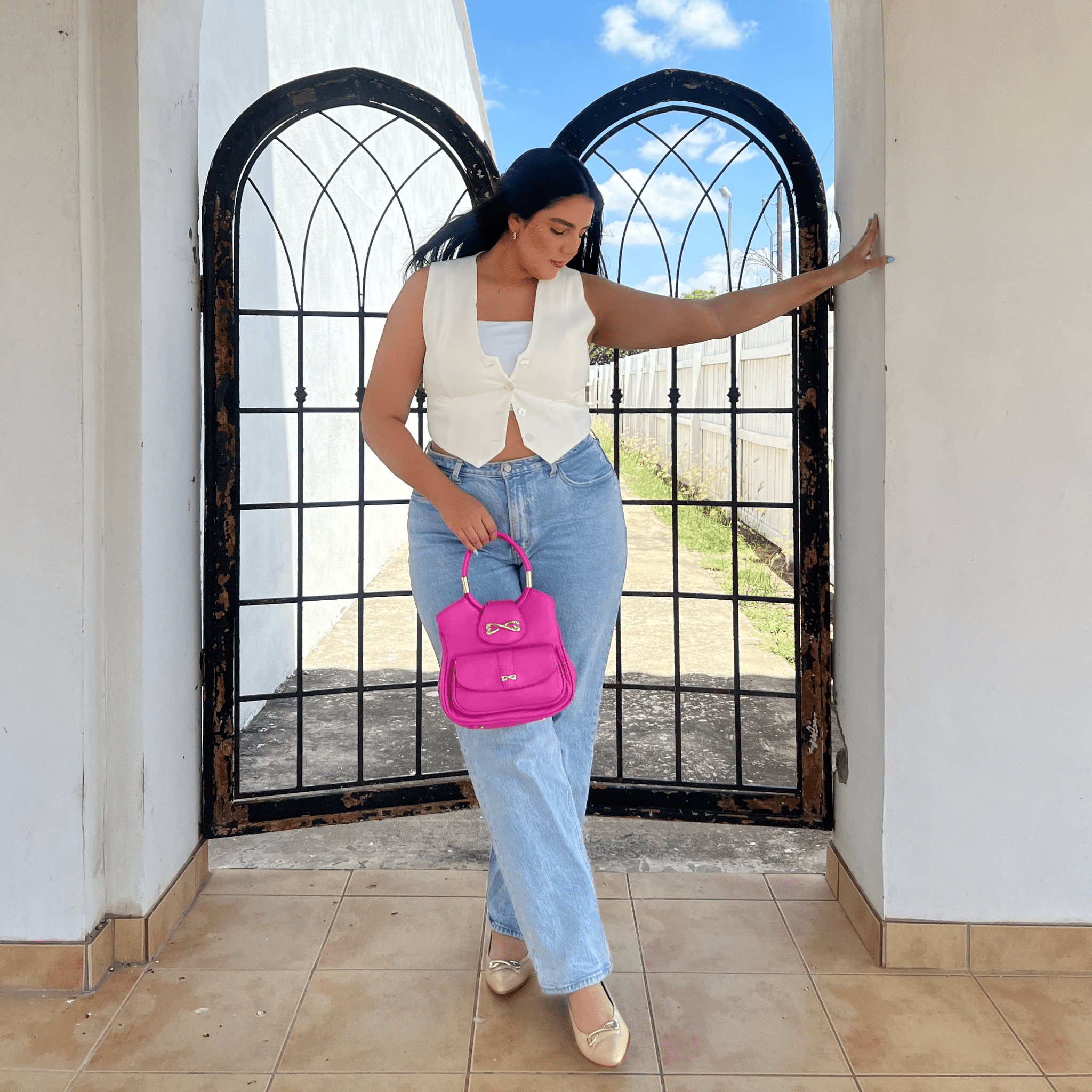 model wearing unique medium pink leather handbag