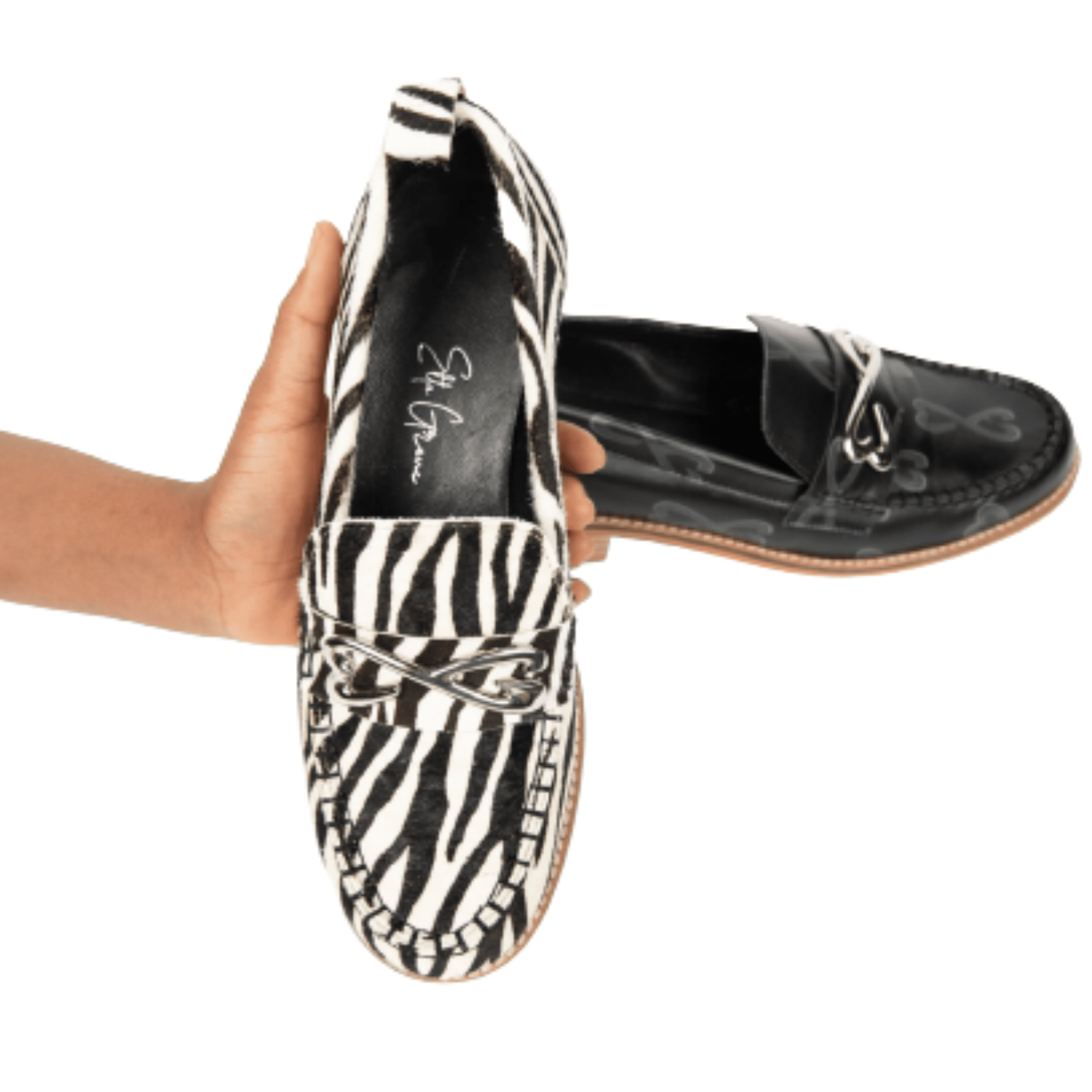woman holding zebra print loafer with black loafer